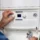 Technician adjusting boiler control panel during 24/7 emergency boiler services Arizona
