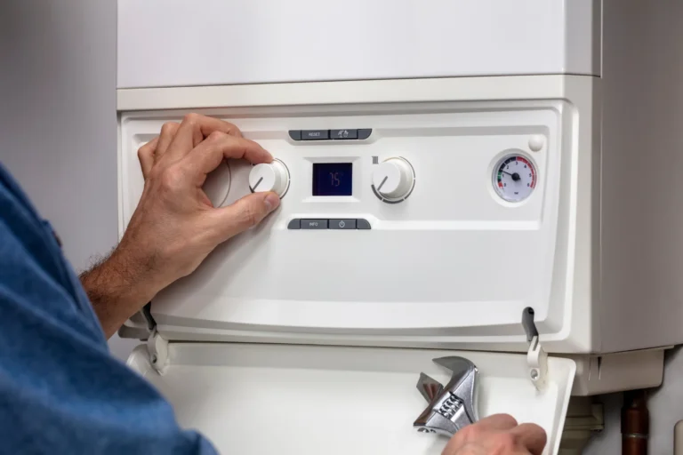 Technician adjusting boiler control panel during 24/7 emergency boiler services Arizona