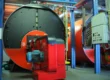 Large industrial boilers with control panels inside a boiler room serviced by boiler services in Arizona