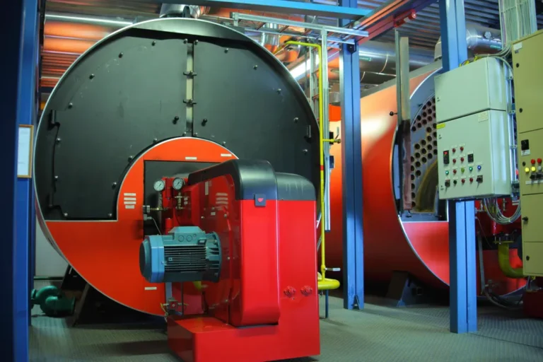 Large industrial boilers with control panels inside a boiler room serviced by boiler services in Arizona