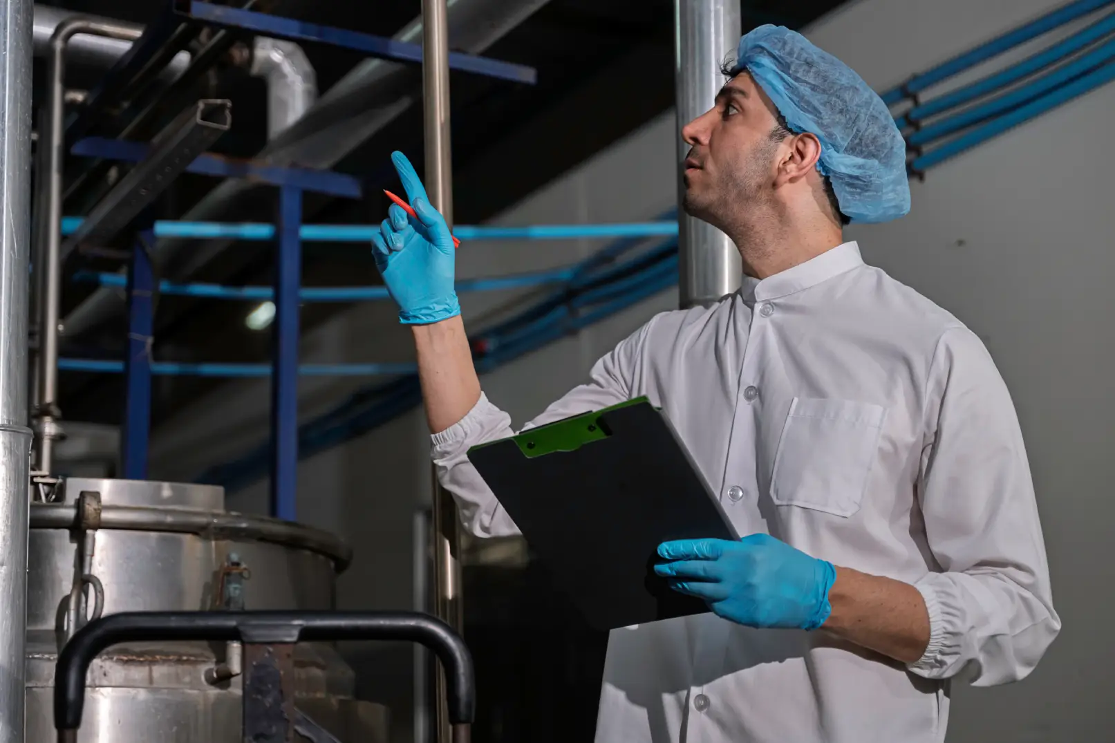 Technician inspecting industrial pressure vessel under ASME code compliance