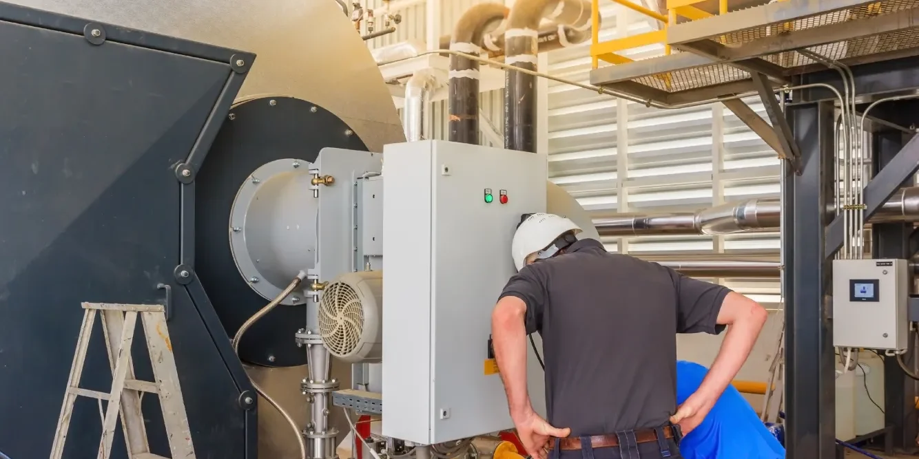 boiler-preventative-maintenance-plans-technicians-service Technicians performing boiler preventative maintenance plans service on industrial boiler control panel and burner system
