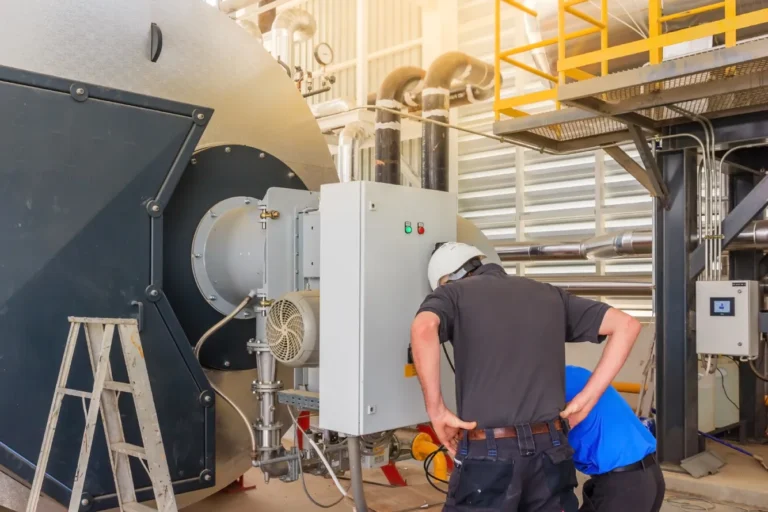 Technicians performing boiler preventative maintenance plans service on industrial boiler control panel and burner system