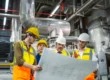 Engineering team reviewing boiler room design plans in a mechanical facility