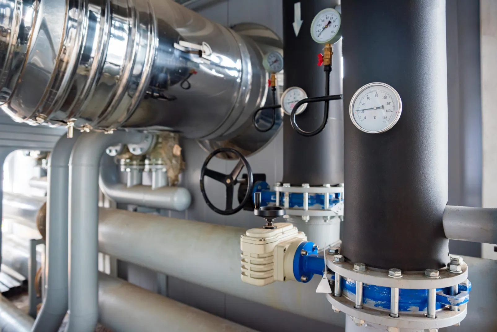 Commercial boiler repair AZ pressure gauges and pipe valves inside a mechanical boiler room