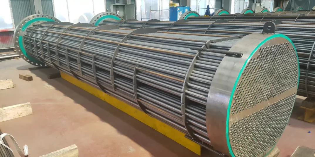 Fully assembled industrial tube bundle with tube sheet and baffles staged in fabrication shop
